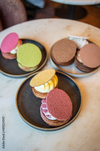 Colourful danish fastelavnsbolle with jam, whipped cream and almond paste in laminated pastry dough with powdered sugar on top served in Copenhagen, Denmark in a cafe bakery Andersen Bakery