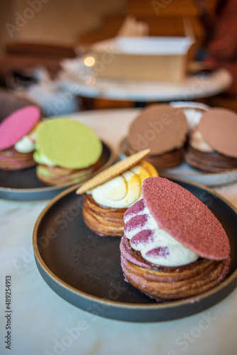 Colourful danish fastelavnsbolle with jam, whipped cream and almond paste in laminated pastry dough with powdered sugar on top served in Copenhagen, Denmark in a cafe bakery Andersen Bakery