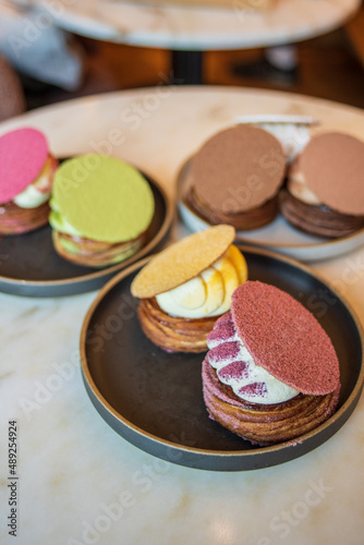 Colourful danish fastelavnsbolle with jam, whipped cream and almond paste in laminated pastry dough with powdered sugar on top served in Copenhagen, Denmark in a cafe bakery Andersen Bakery