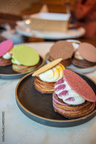 Colourful danish fastelavnsbolle with jam, whipped cream and almond paste in laminated pastry dough with powdered sugar on top served in Copenhagen, Denmark in a cafe bakery Andersen Bakery