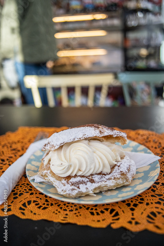 Danish fastelavnsbolle with jam, whipped cream and almond paste in laminated pastry dough with powdered sugar on top served in Copenhagen, Denmark in a caffe Granny's House