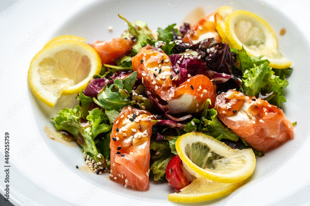 Salmon fish salad. Fresh vegetable lettuce and salmon fish fillet, healthy food, omega 3, keto diet, mediterranean cusine top view