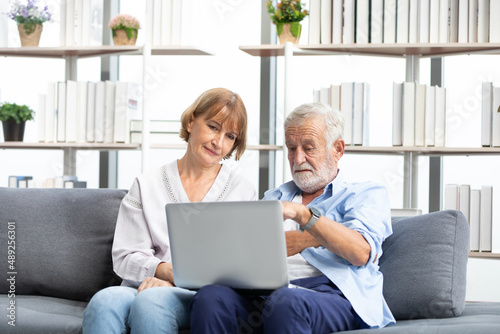 senior couple using laptop computer on sofa