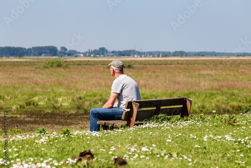 Senior man with cap enjoying the view at island and nature reserve Tiengemeten Hoeksche Waard n South Holland in The neteherlands