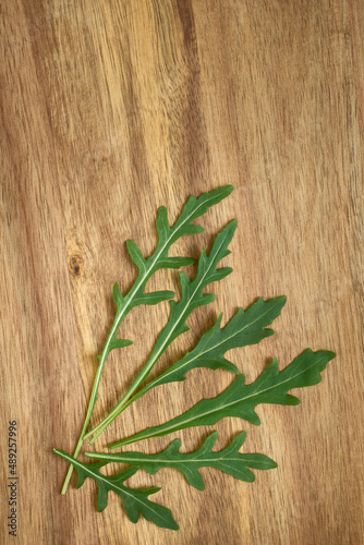 Arugula leaves on wooden background close up