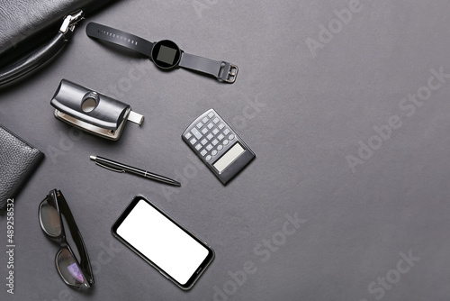 Gadgets, stationery and eyeglasses on dark background