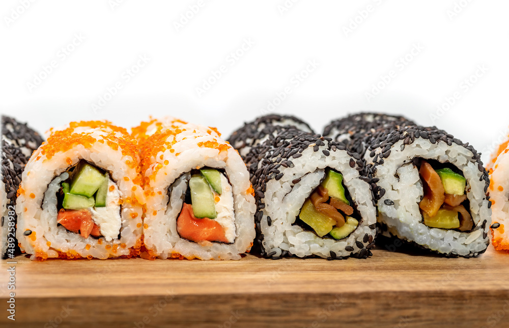 Close view of Sushi rolls in a Japanese restaurant. Appetizer Makizushi delicious traditional food of rice, seafood, avocado, fish salmon Close view of Sushi rolls in a Japanese restaurant. Appetizer Makizushi delicious traditional food of rice, seafood, avocado, fish salmon