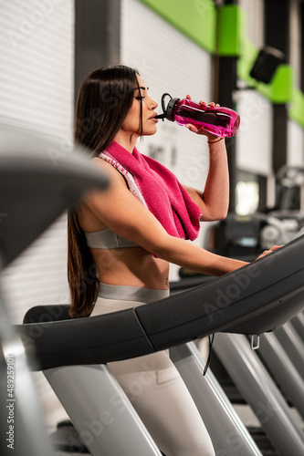 Una guapa mujer caucásica haciendo deporte en una cinta de caminadora