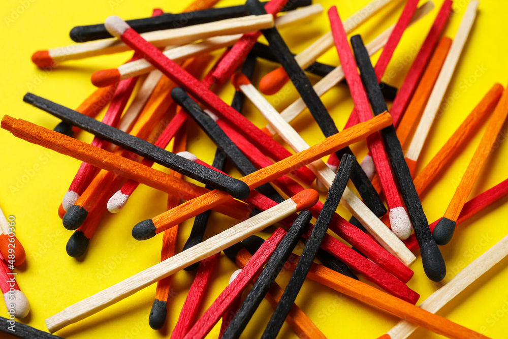 Fototapeta premium Heap of different new matchsticks on yellow background, closeup