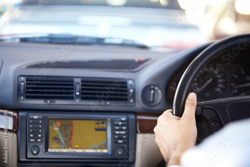 Your destination awaits.... Cropped image of a gps navigation system and a mans hands on the steering wheel of a car. © D M/peopleimages.com