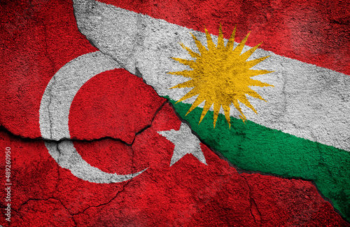 Full frame photo of weathered flags of Turkey and Kurdistan painted on a cracked wall. Kurdish–Turkish conflict concept. photo