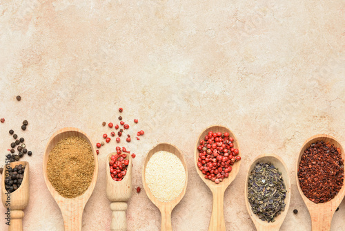 Fototapeta Naklejka Na Ścianę i Meble -  Spoons with aromatic spices on beige background