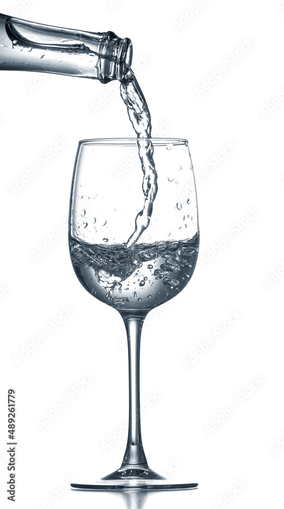 Pouring of clear water in glass isolated on white Pouring of clear water in glass isolated on white