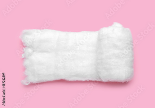 Roll of soft cotton wool on pink background