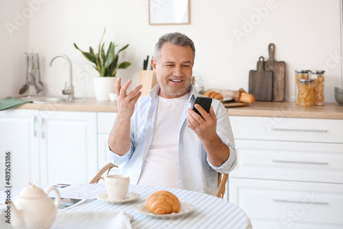 Senior man using mobile pho...