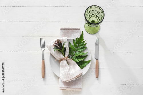 Stylish simple table setting on light wooden background