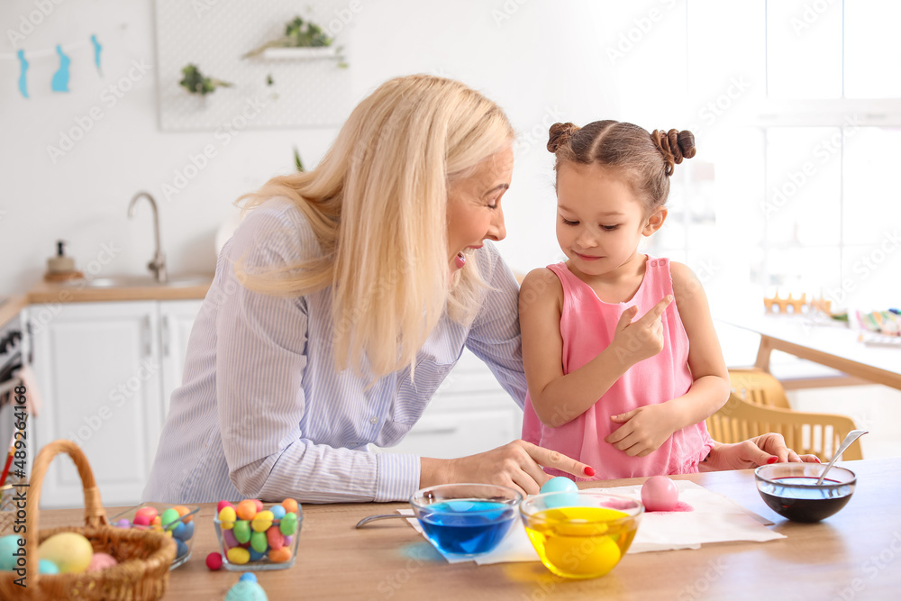 Little girl and her grandmother painting Easter eggs at home Little girl and her grandmother painting Easter eggs at home