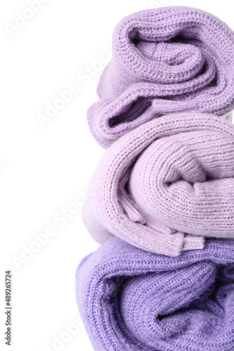 Stack of rolled lilac sweaters on white background, closeup