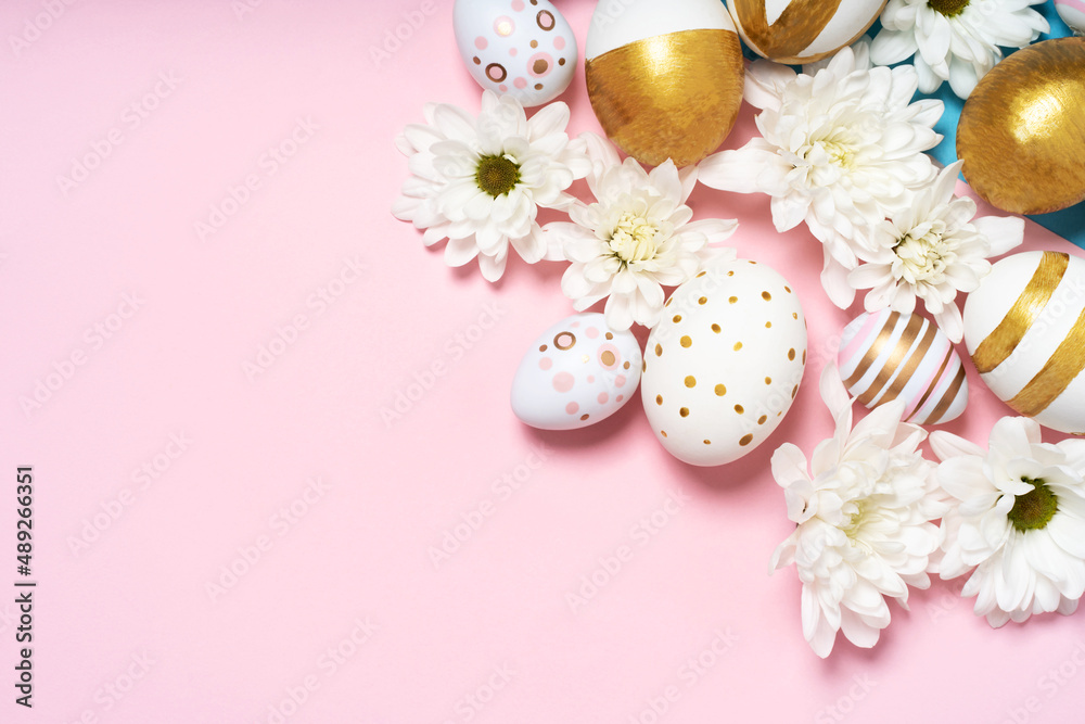 Hand-drawn easter eggs and spring white flowers on pink pastel background. Many easter eggs flat lay background.