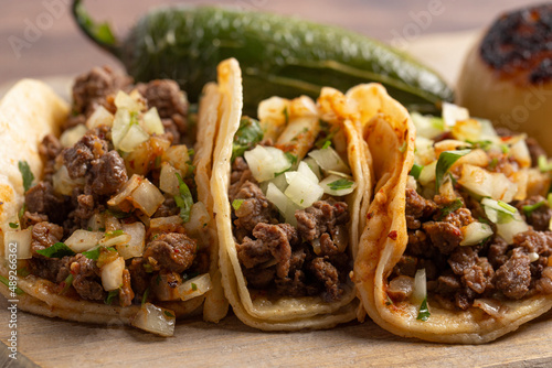 Fototapeta Naklejka Na Ścianę i Meble -  Three Beef Steak Street Tacos in a Row on a Wooden Platter