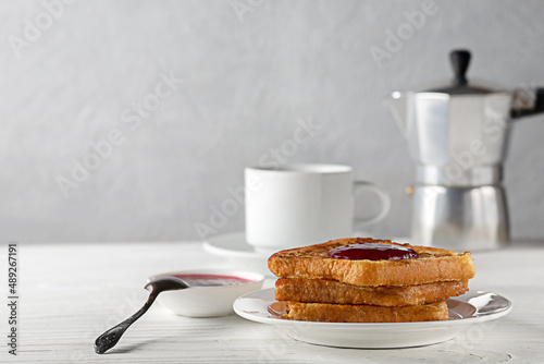 Toasted bread with jam and a cup of hot coffee on a wooden table photo