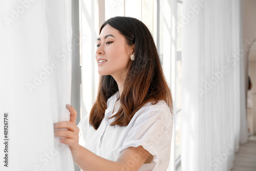 Free Download Pretty young Asian woman near window - GFXLoad