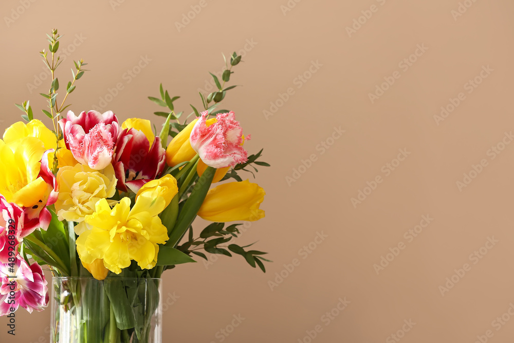 Fototapeta premium Vase with tulips and eucalyptus branches on beige background, closeup