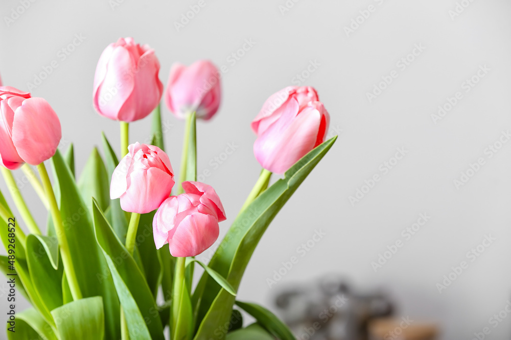 Fototapeta premium Closeup view of beautiful tulips on light background