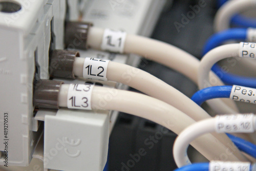 Connection of circuit breakers located on the din rail in the electrical panel close-up.