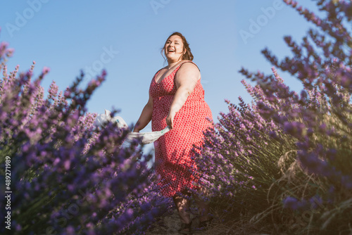 smiling beautiful plus size woman in a lavender field.