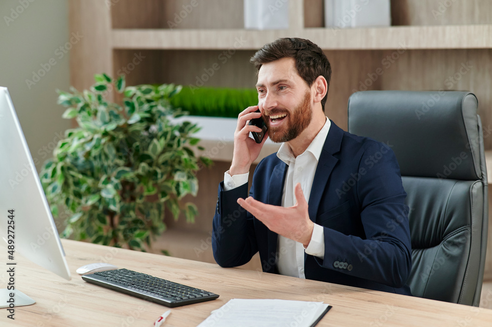 entepreneur speakinh on the phone and smiling, Bearded man in a suit with a nice smile.