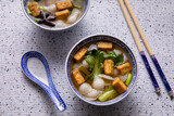 Pho soup with fried tofu cubes, noodles, pak choi and vegetables. Homemade Vegan Asian Vietnamese cuisine food.
