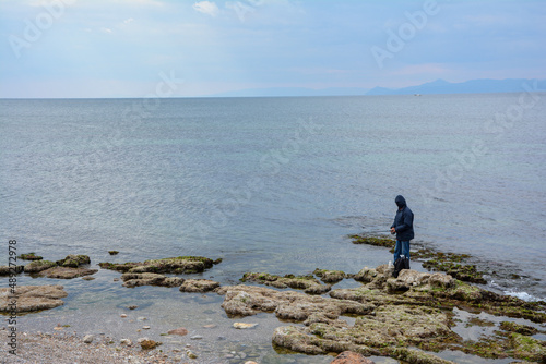 man watching the sea on the rocks