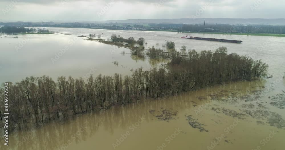 Aerial view of floodplains with trees during high water in the river Waal with a boat passing by, Gendtse Waard, Gelderland, Netherlands. Aerial view of floodplains with trees during high water in the river Waal with a boat passing by, Gendtse Waard, Gelderland, Netherlands.