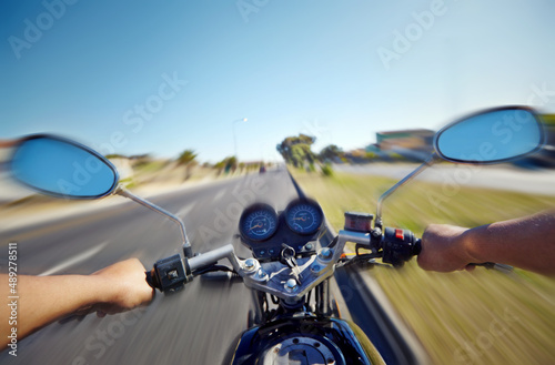 Cruising down the highway. POV shot of a person riding a motorcycle. © Nathan C P/peopleimages.com