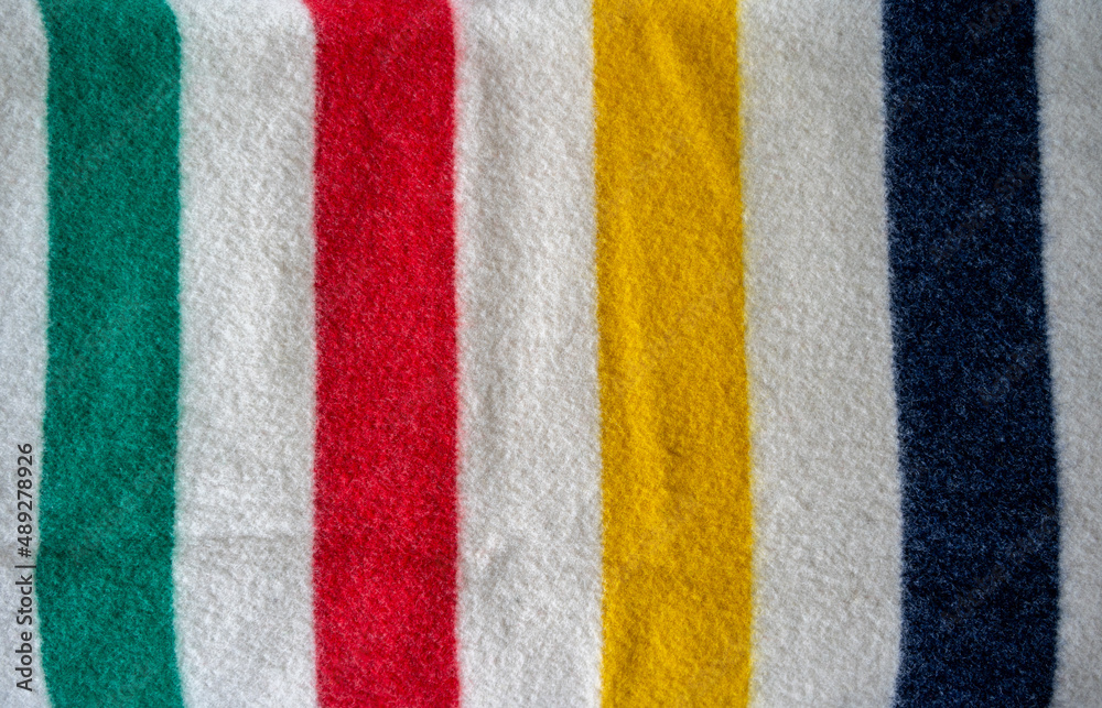Fototapeta premium Detail of a bay blanket with green, red, yellow and blue stripes.