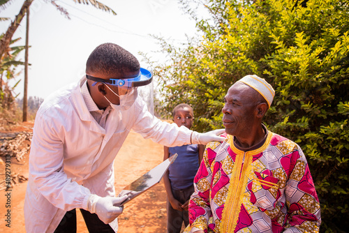 African doctor visits an elderly patient and they converse during the medical examination. Health care in africa concept