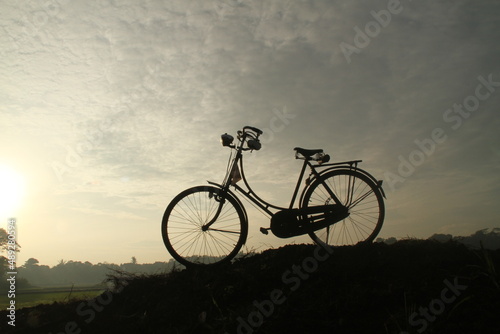 silhouette of an old bicycle by the rice field, indonesia 