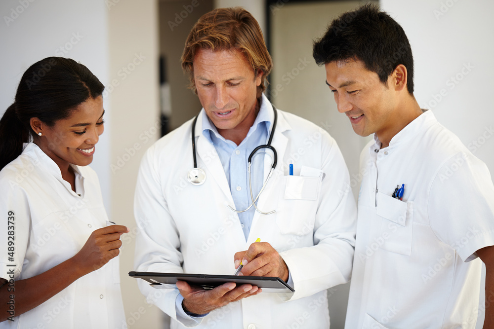 This diagnosis is so fascinating. Shot of three doctors looking at a digital tablet. This diagnosis is so fascinating. Shot of three doctors looking at a digital tablet.