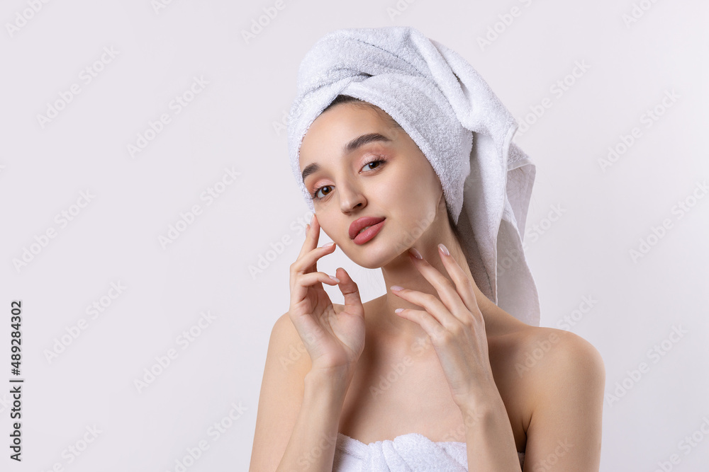 Beautiful girl with thick eyebrows and perfect skin at white background, towel on head, beauty photo. Beautiful girl with thick eyebrows and perfect skin at white background, towel on head, beauty photo.