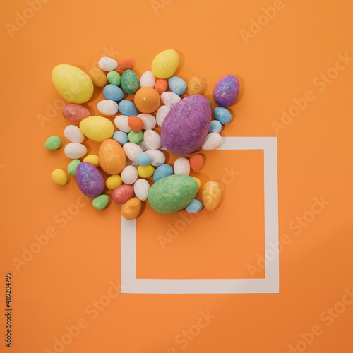 minimal creative cocncept composition with colorful easter egg on orange beckground with copyspace square photo