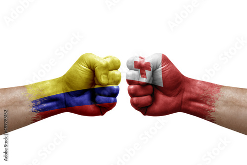 Two hands punch to each others on white background. Country flags painted fists, conflict crisis concept between colombia and tonga