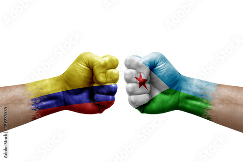 Two hands punch to each others on white background. Country flags painted fists, conflict crisis concept between colombia and djibouti
