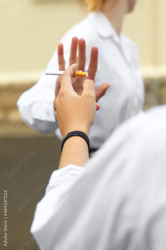 Naklejka premium Saying no. Cropped shot of a young female studentd turning down cigarettes in response to peer pressure.