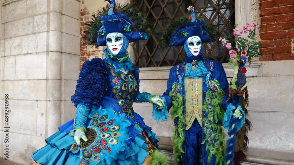 Venice, Italy - February 2022 - carnival masks are photographed with tourists in San Marco square Venice, Italy - February 2022 - carnival masks are photographed with tourists in San Marco square