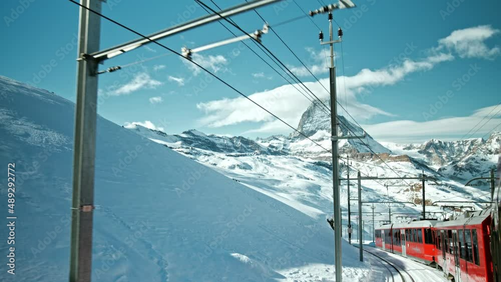 Traveling by a modern Swiss Train down the Alps with a view of the Matterhorn. A train going down from the top of the mountains in Gornergrat, Zermatt, Switzerland.