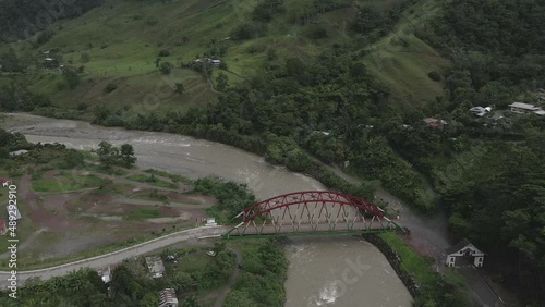 Aerial tilt to bridge near Pozuzo Arch in Huancabamba Valley of Peru photo