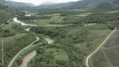 Aerial tilt to winding Huancabamba River in cloudy green valley, Peru photo