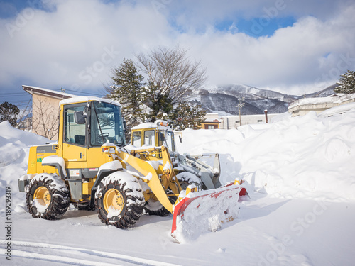 yellow snowplow vehicles and piled up snow beside them