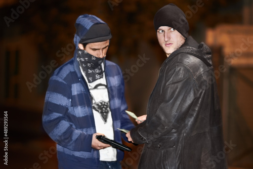 Underworld dealings. Two criminal doing a shady deal while wielding a gun.